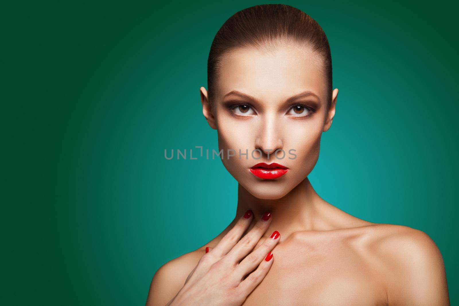 Close-up portrait of sexy caucasian young woman with red glamour make-up and bright manicure over green background