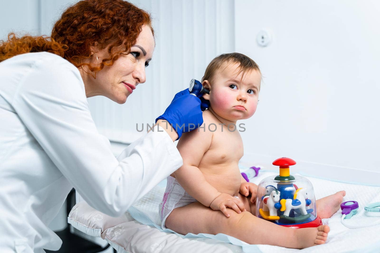 Pediatrician providing healthcare for her baby patient in the office of a specialized clinic for children. Neonatologist. Medical appointment little child one year old in the clinic. Health care of infant, children, kid.