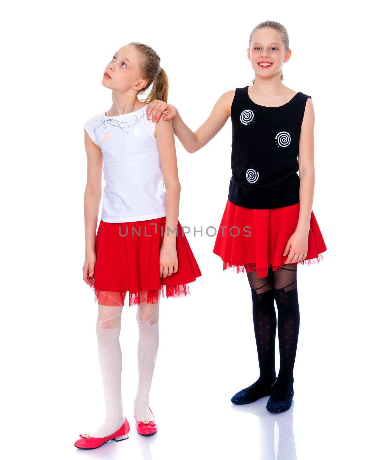 Two cute little girls in full growth, in the studio on a white background. The concept of a happy childhood, Beauty and fashion. Isolated.