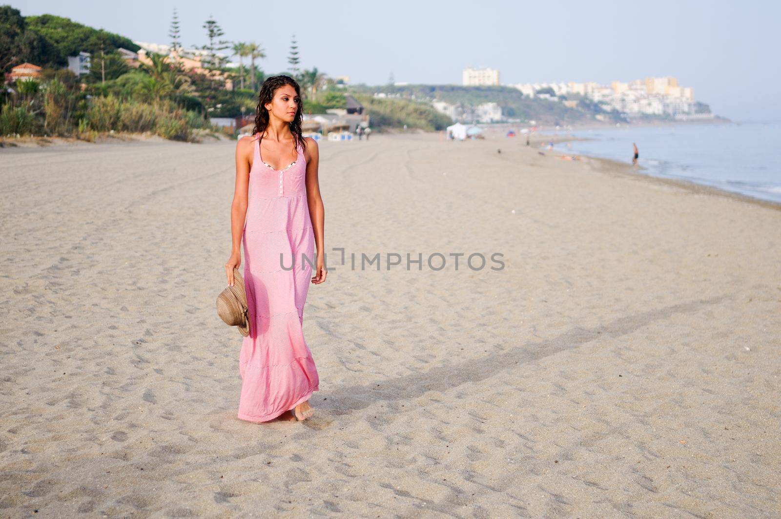Beautiful woman with long pink dress on a tropical beach by javiindy