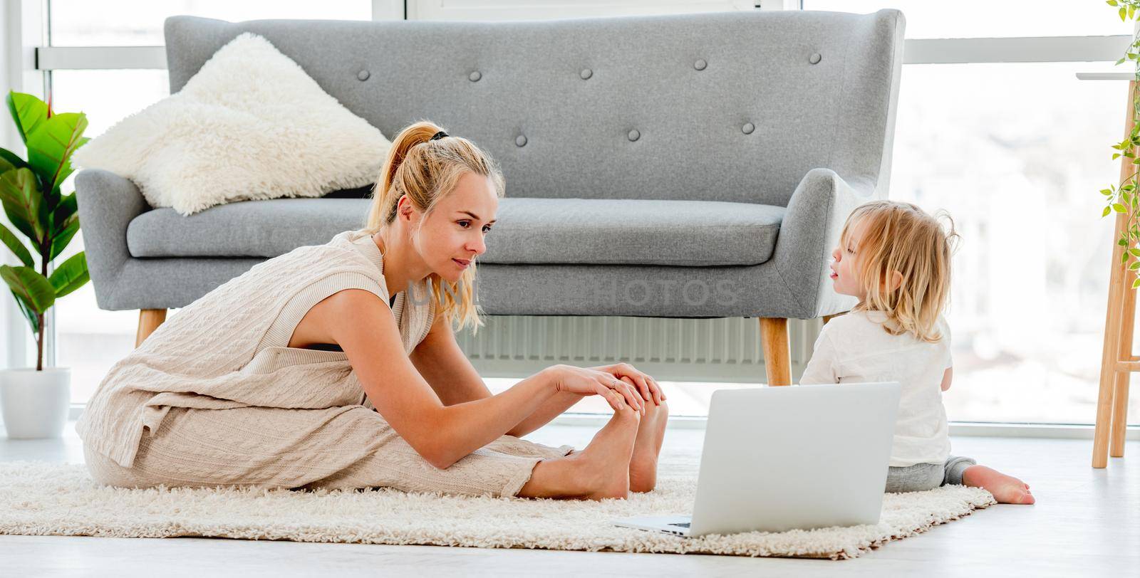 Mother with child exercising with laptop by tan4ikk1