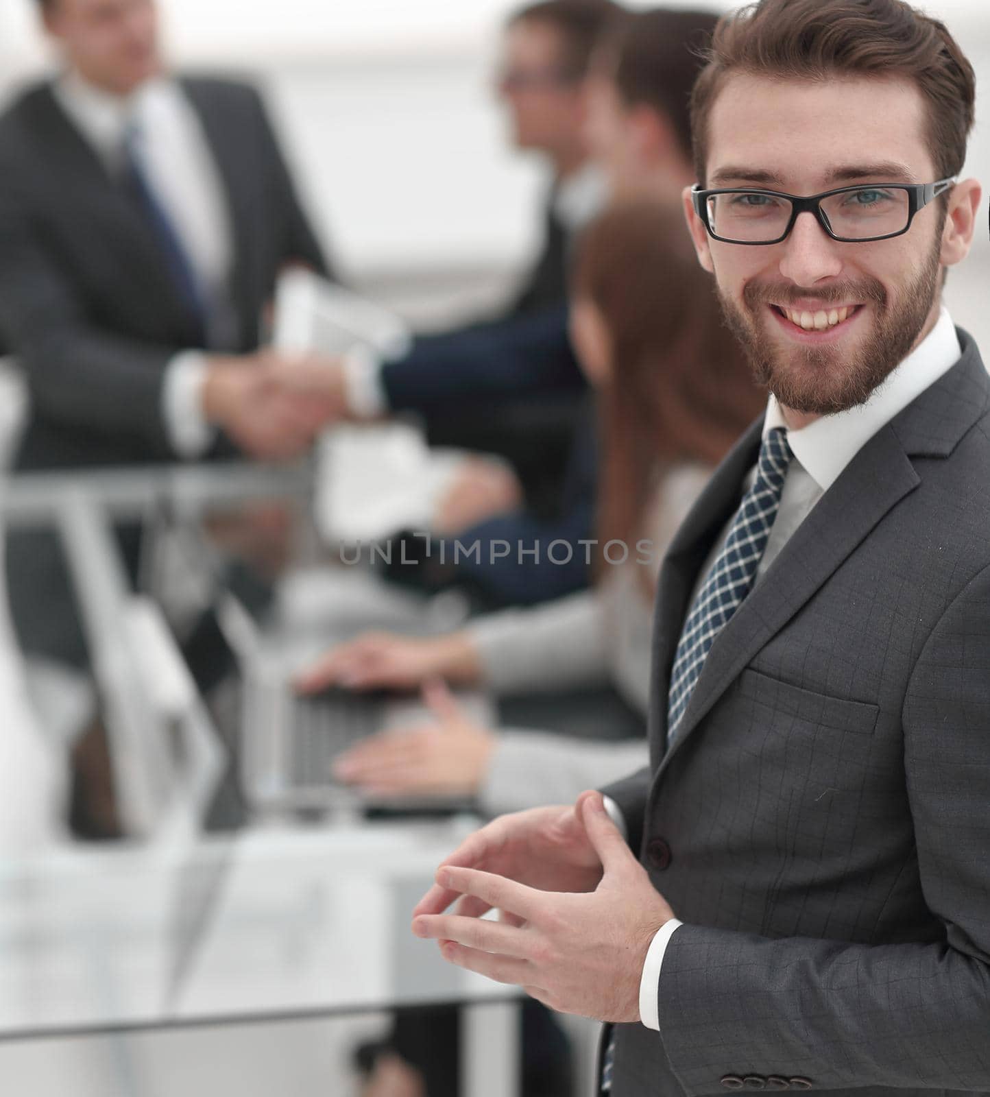 smiling businessman on background of office by asdf