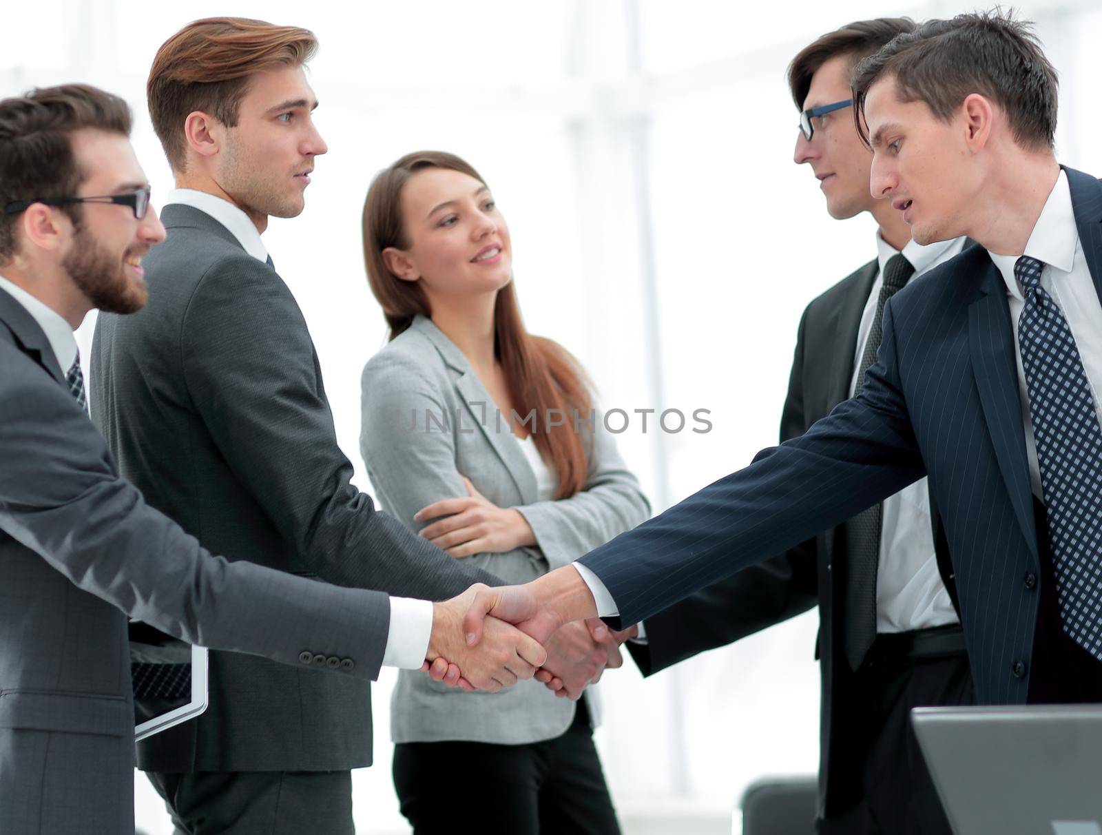 leaders of business teams shake hands by asdf