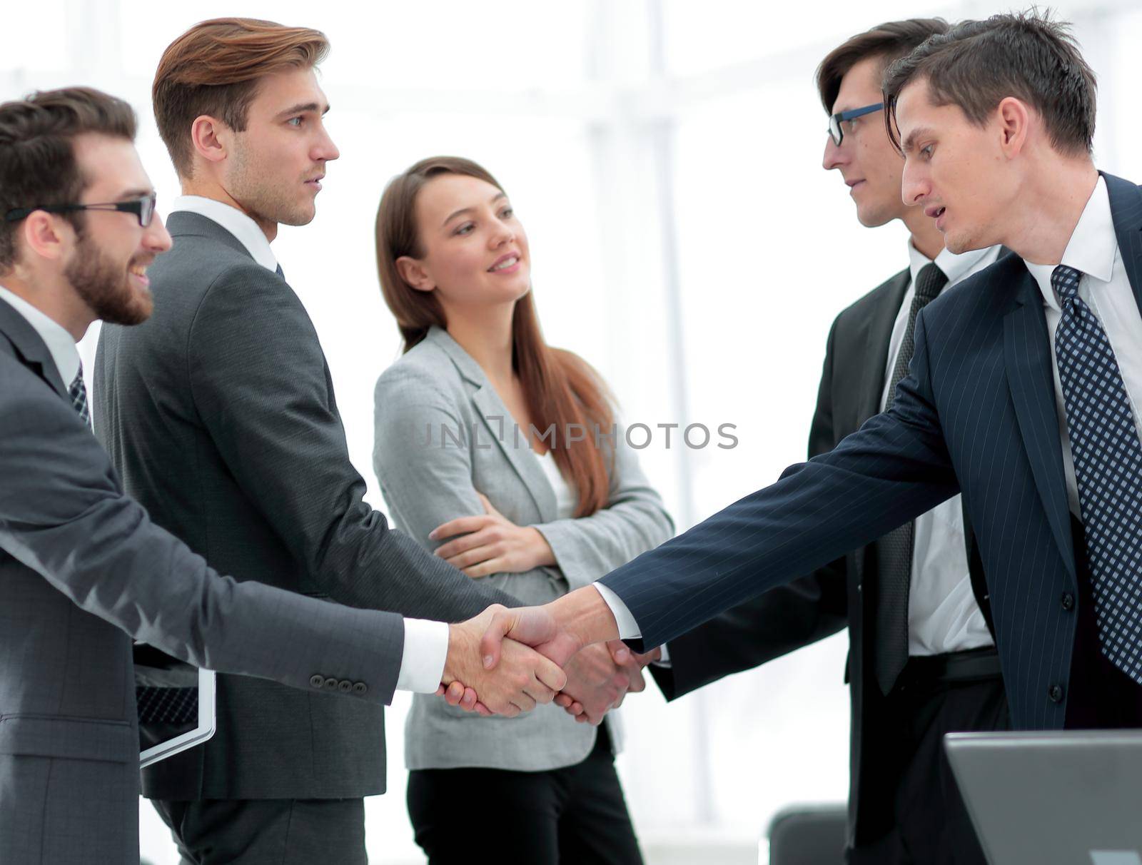 leaders of business teams shake hands.