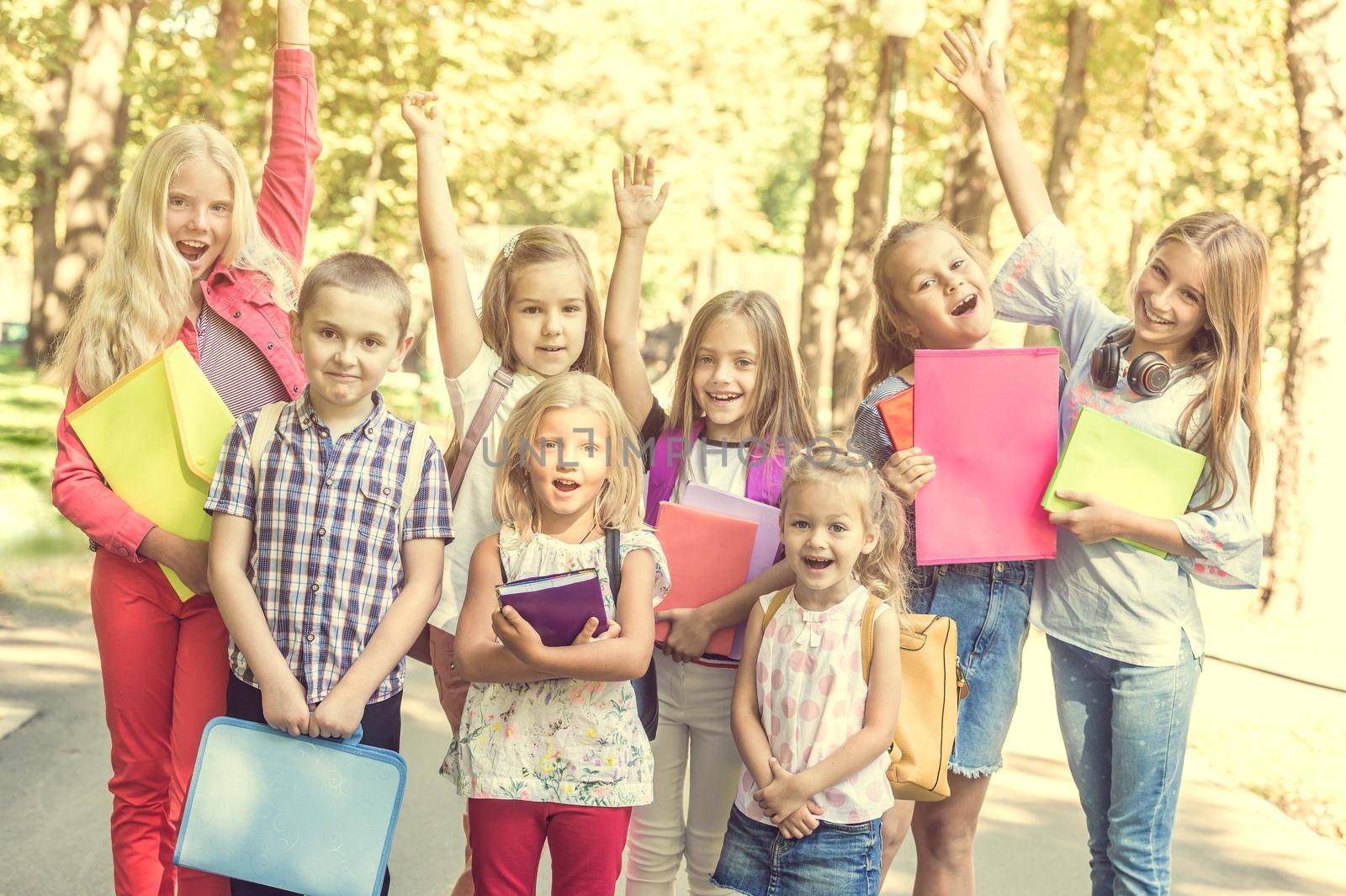 group of children with school backpacks in the park