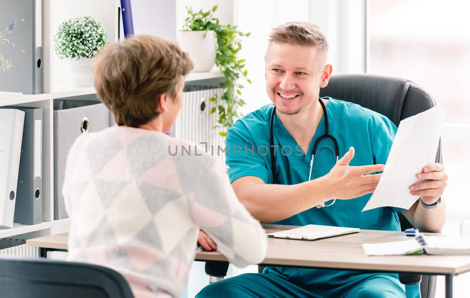 Smiling therapist talking to woman patient during appointment in medical clinic