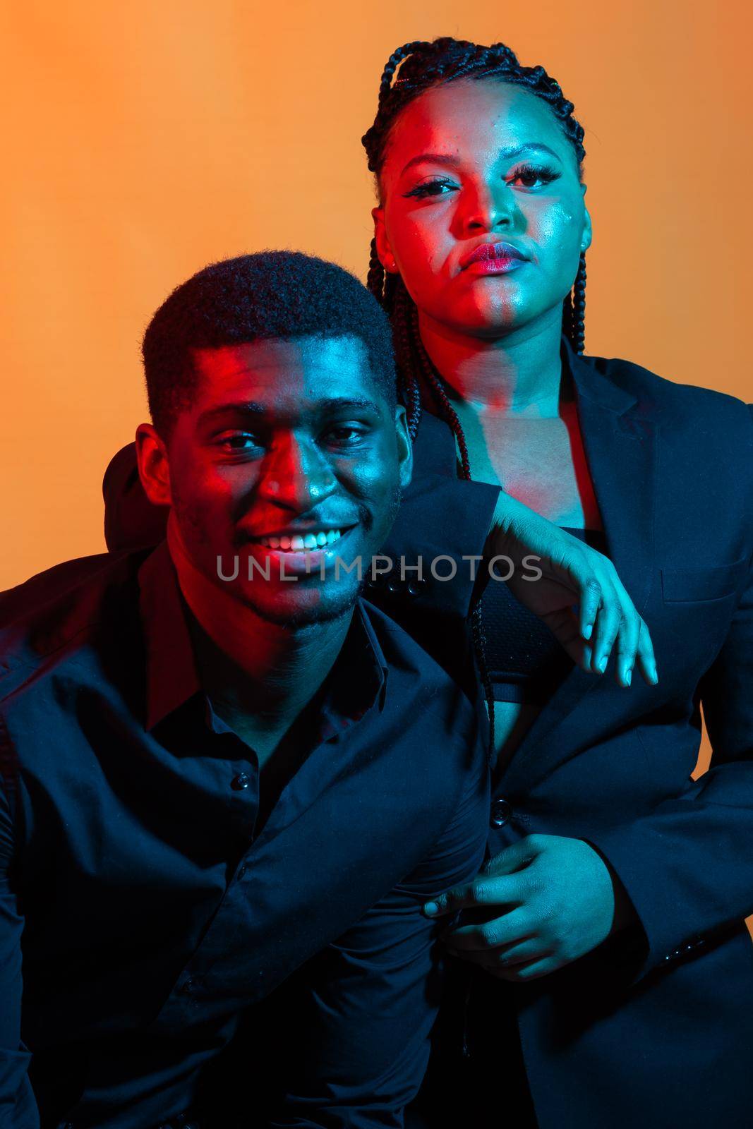 Portrait of young african american couple in love posing at studio dressed in classic clothes. Neon light. by Satura86