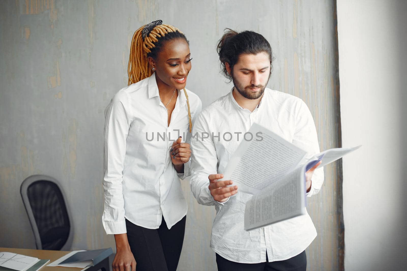 Handsome man in a white shirt. African woman with partner. Guy with a laptop.