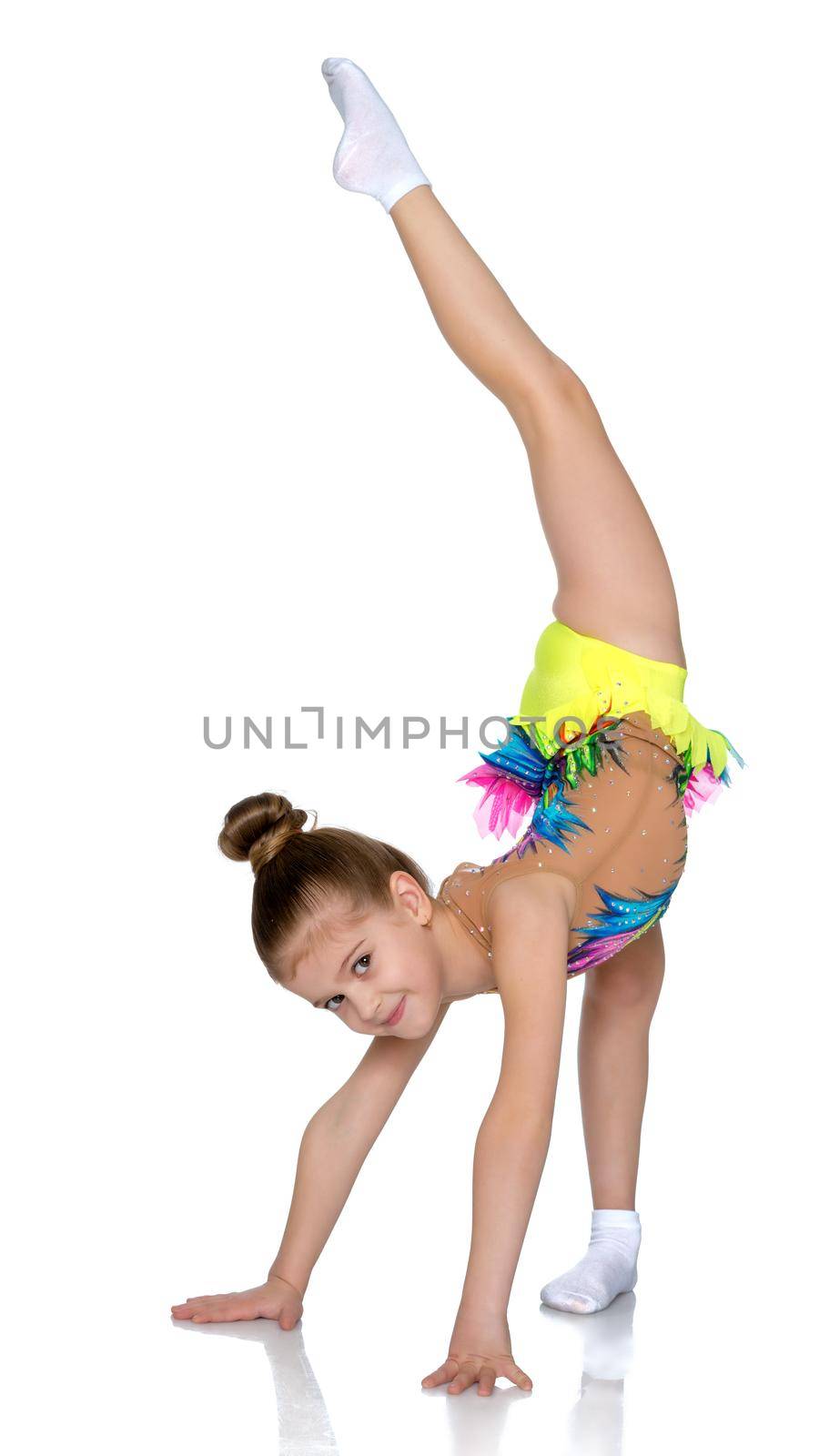 A gymnast girl prepares for the exercise. The concept of childhood and sport, a healthy lifestyle. Isolated on white background.