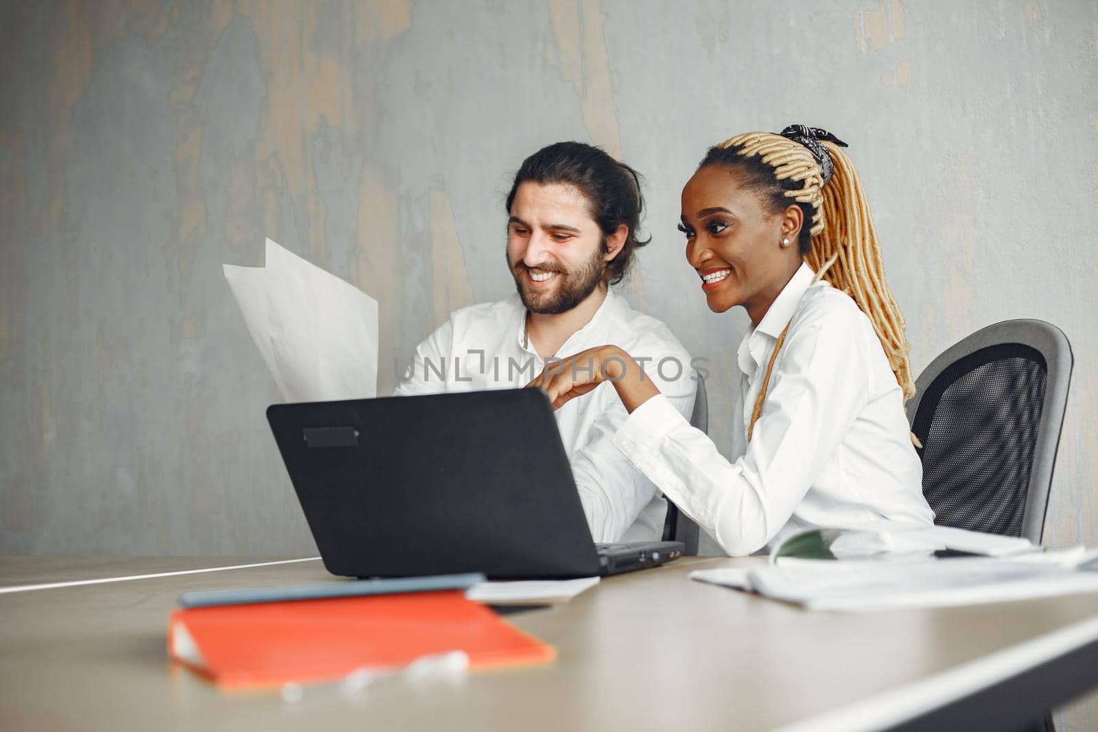 Handsome man in a white shirt. African woman with partner. Guy with a laptop.