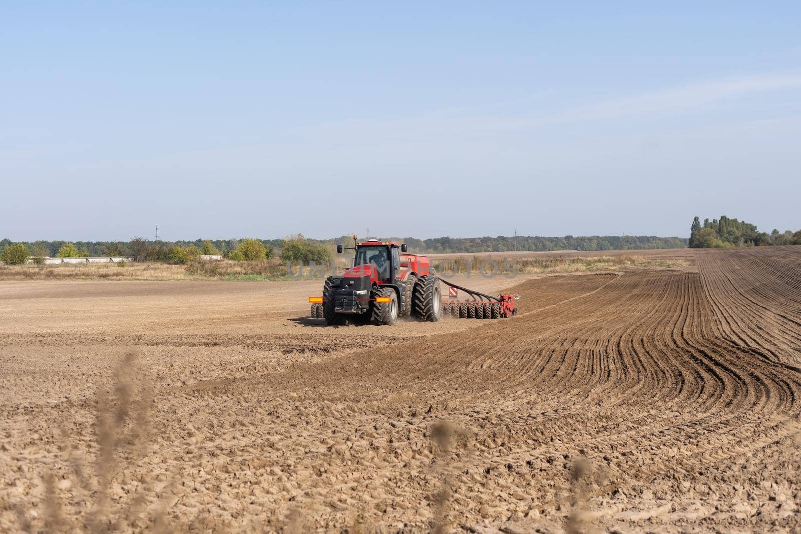 Tractor cultivating soil and preparing a field for planting