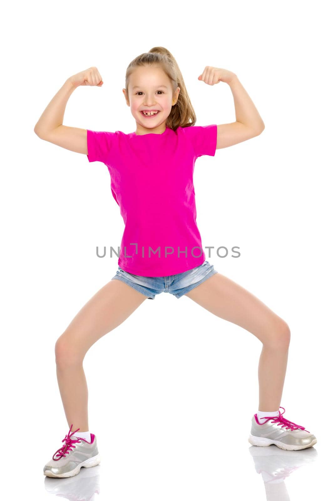 Beautiful little girl shows her muscles. The concept of strength, health and sport. Isolated on white background.