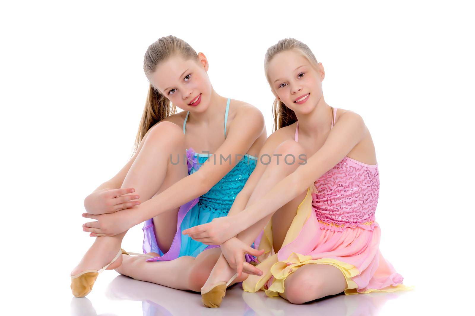 Girls gymnasts sit on the floor. by kolesnikov_studio