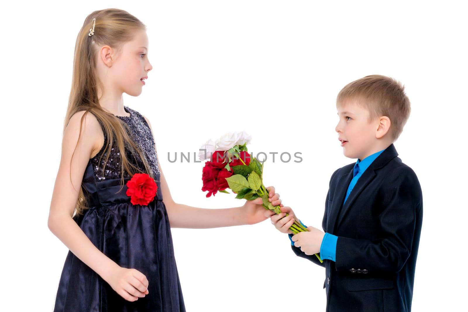 A little boy gives a little girl flowers. The concept of a happy childhood, love. Isolated on white background.