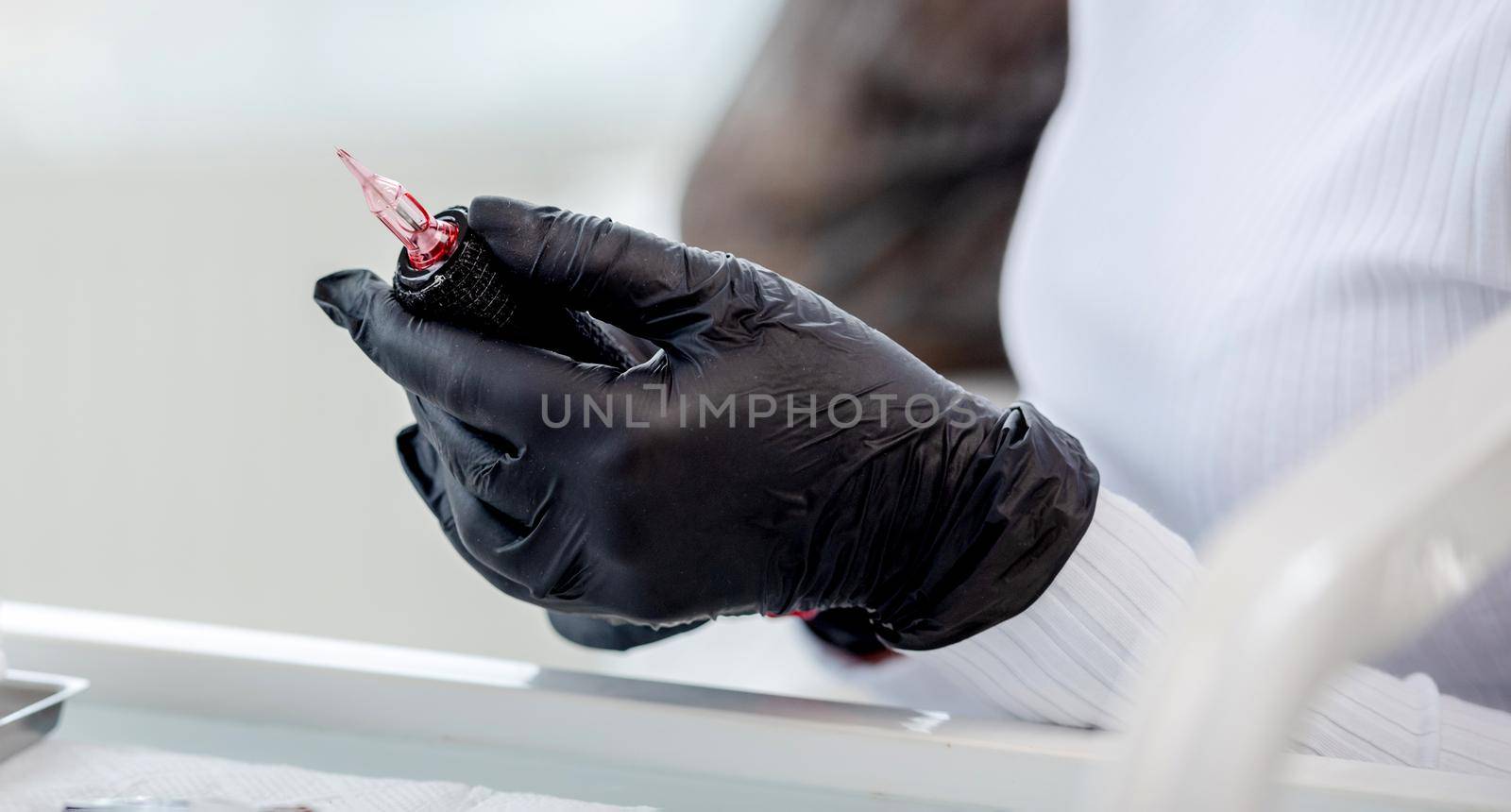 Permanent makeup master preparing tools for microblading. Closeup portrait of cosmetologist hands