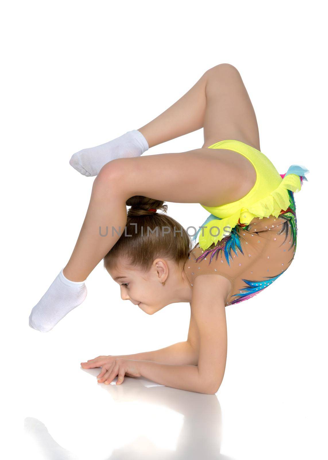 A girl gymnast performs an exercise stance on her forearms.The concept of childhood, sport, a healthy lifestyle. Isolated on white background.