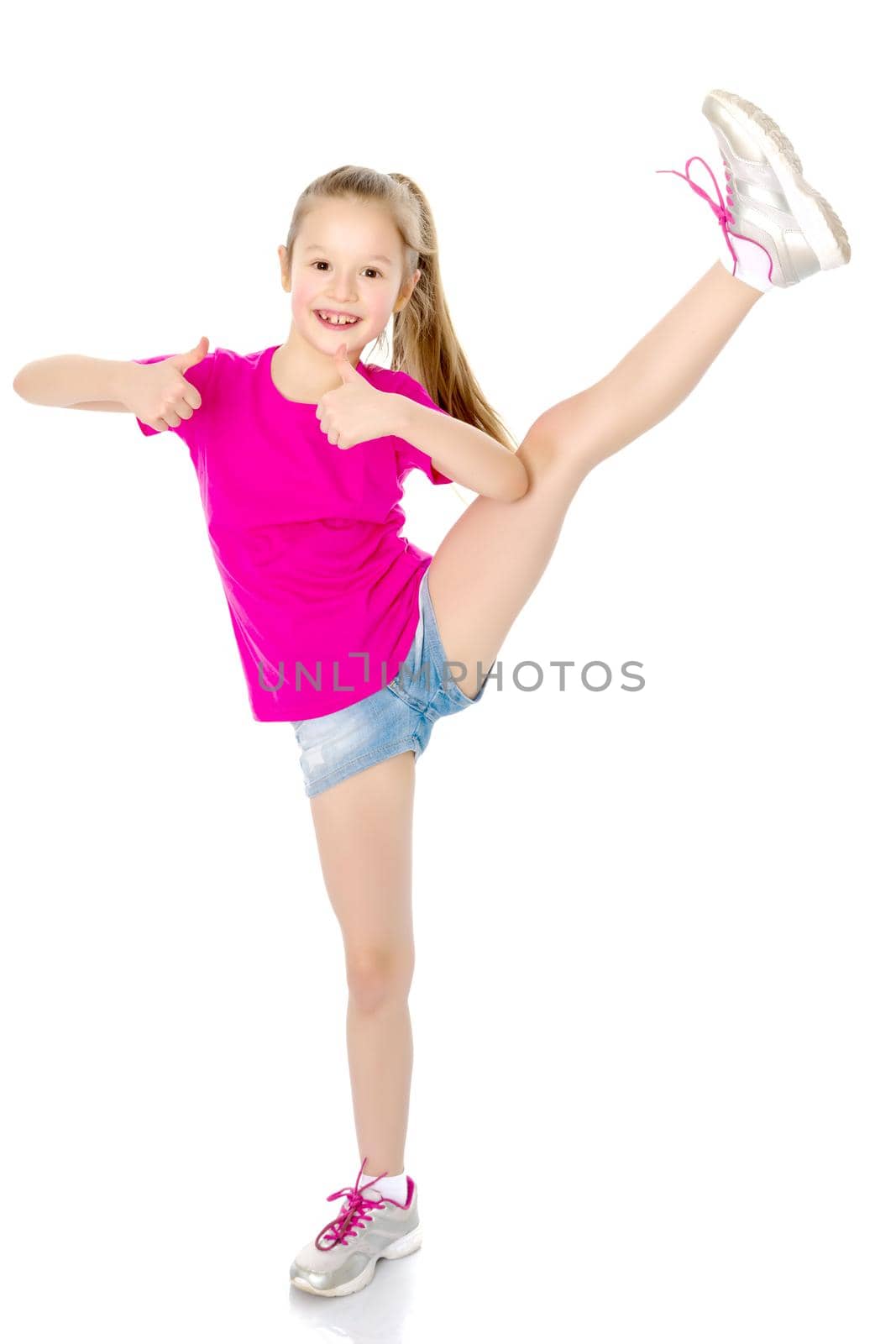 A sweet little girl shows gymnastic exercises that she learned at a sports school. The concept of sport and fitness. Isolated on white background.