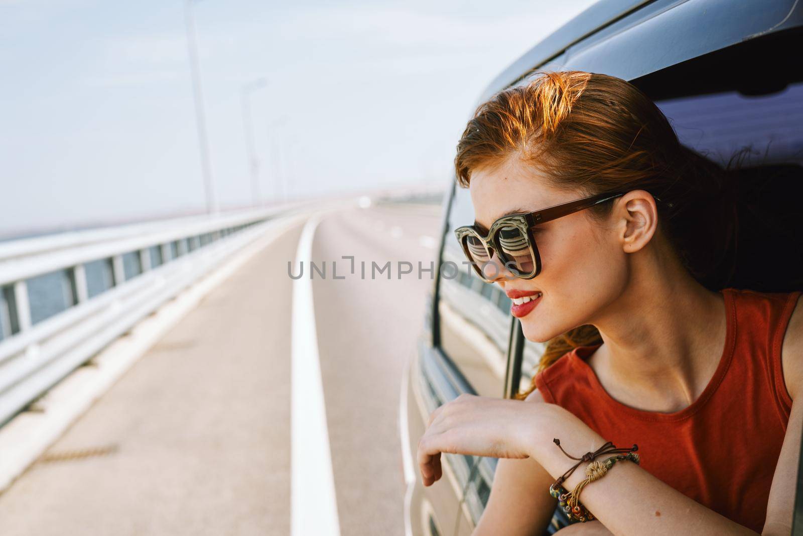 pretty woman in sunglasses rides in a travel car. High quality photo