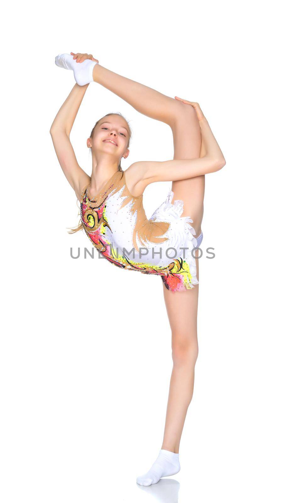 A girl gymnast balances on one leg.The concept of childhood, sport, a healthy lifestyle. Isolated on white background.