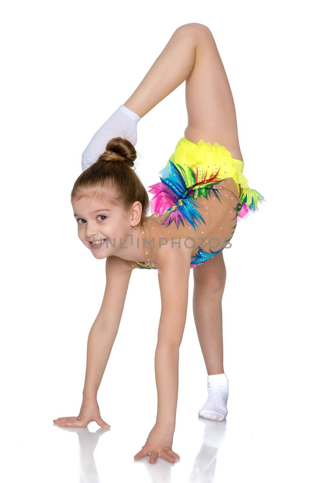 A girl gymnast balances on one leg.The concept of childhood, sport, a healthy lifestyle. Isolated on white background.