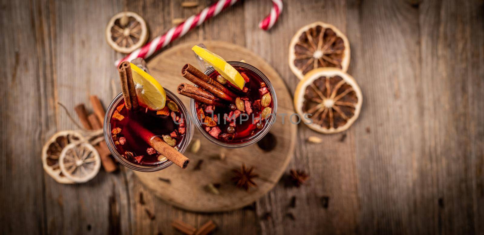 Top view of pair of glasses with aromatic mulled wine standing on wooden background