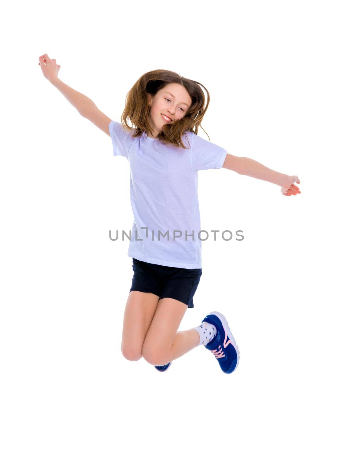 A little girl gymnast joyfully jumps and wags her hands. The concept of sport and fitness. Isolated over white background