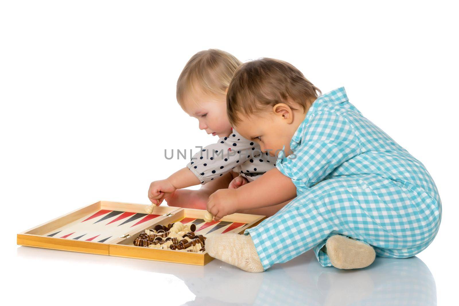 Baby boy and girl, play chess or backgammon. The concept of a harmonious development of a child in the family, a happy childhood. Isolated on white background.