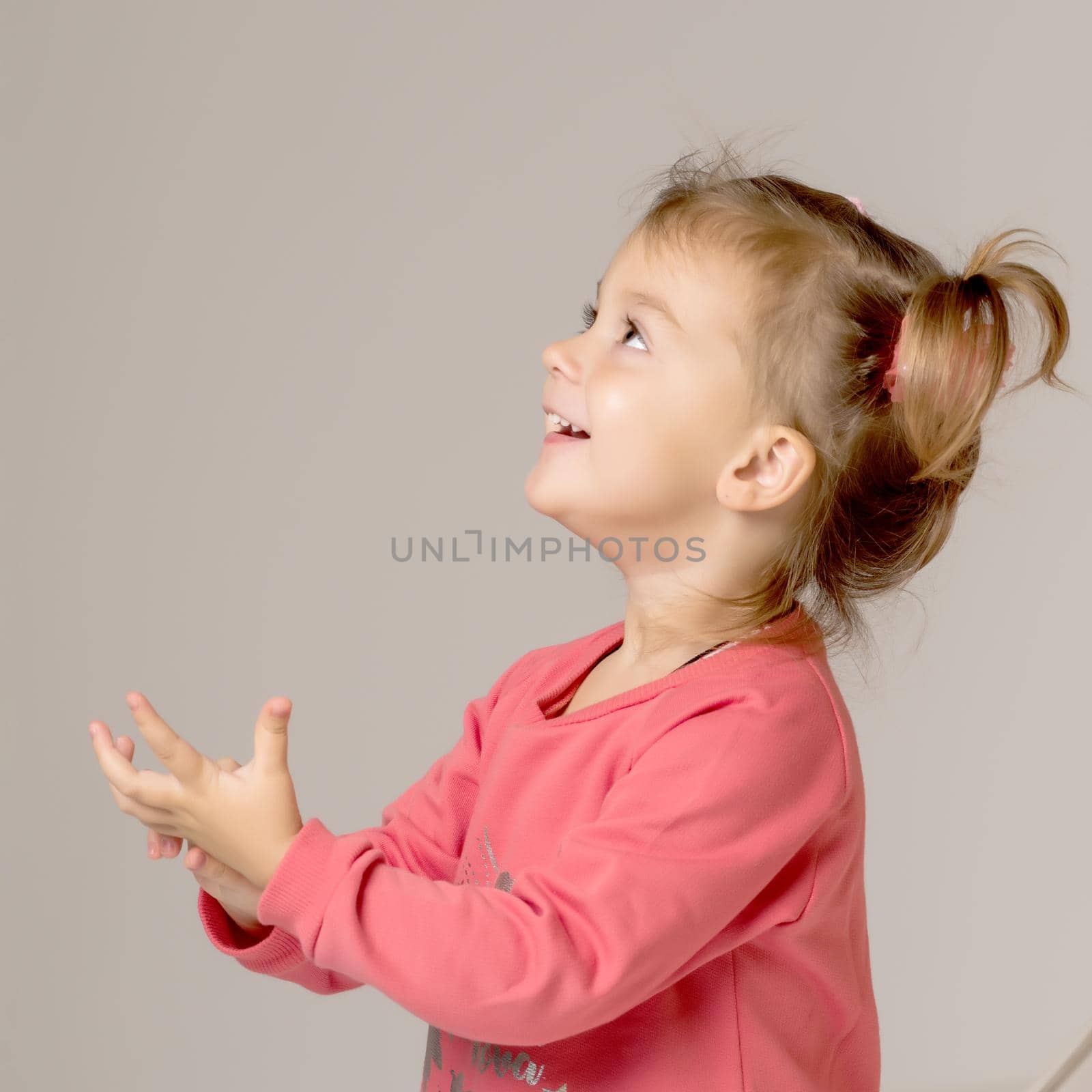 A nice little girl is waving her hand. Close-up. The concept of children's emotions, happy family. Isolated on white background.