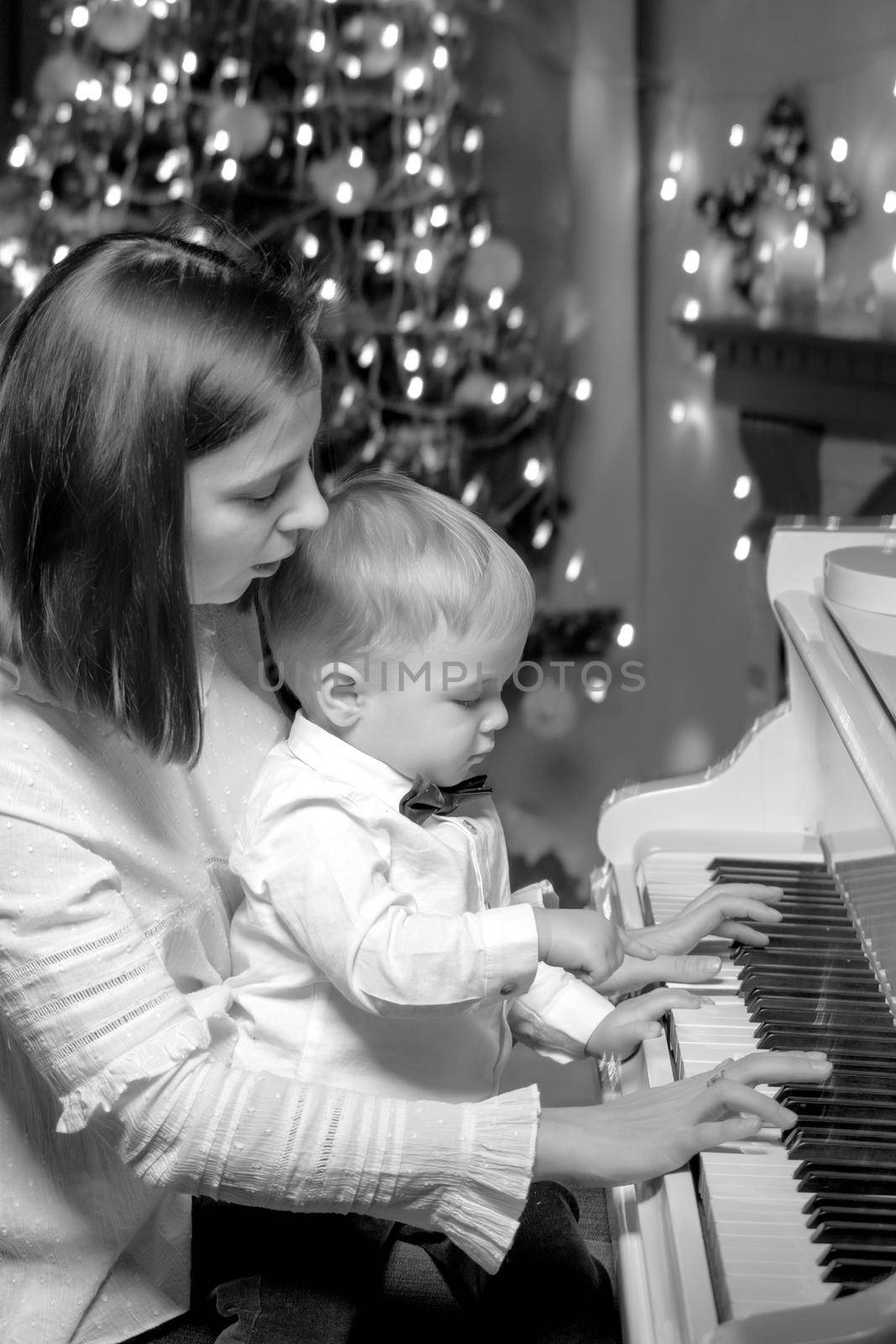 Mom with a child near a white piano by kolesnikov_studio