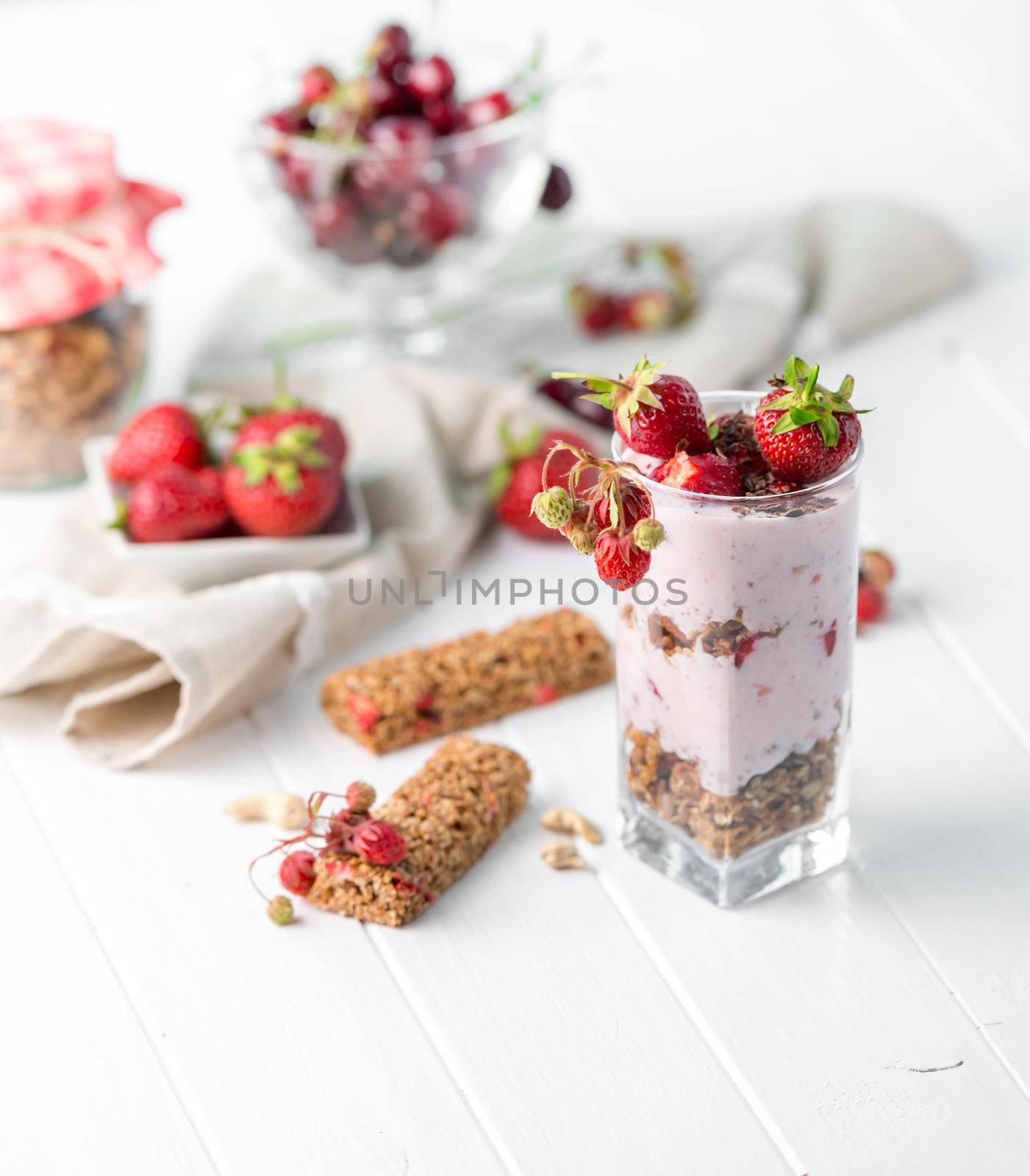 Tasty granola with nuts and yoghurt, berries on the side, healthy breakfast, sideview