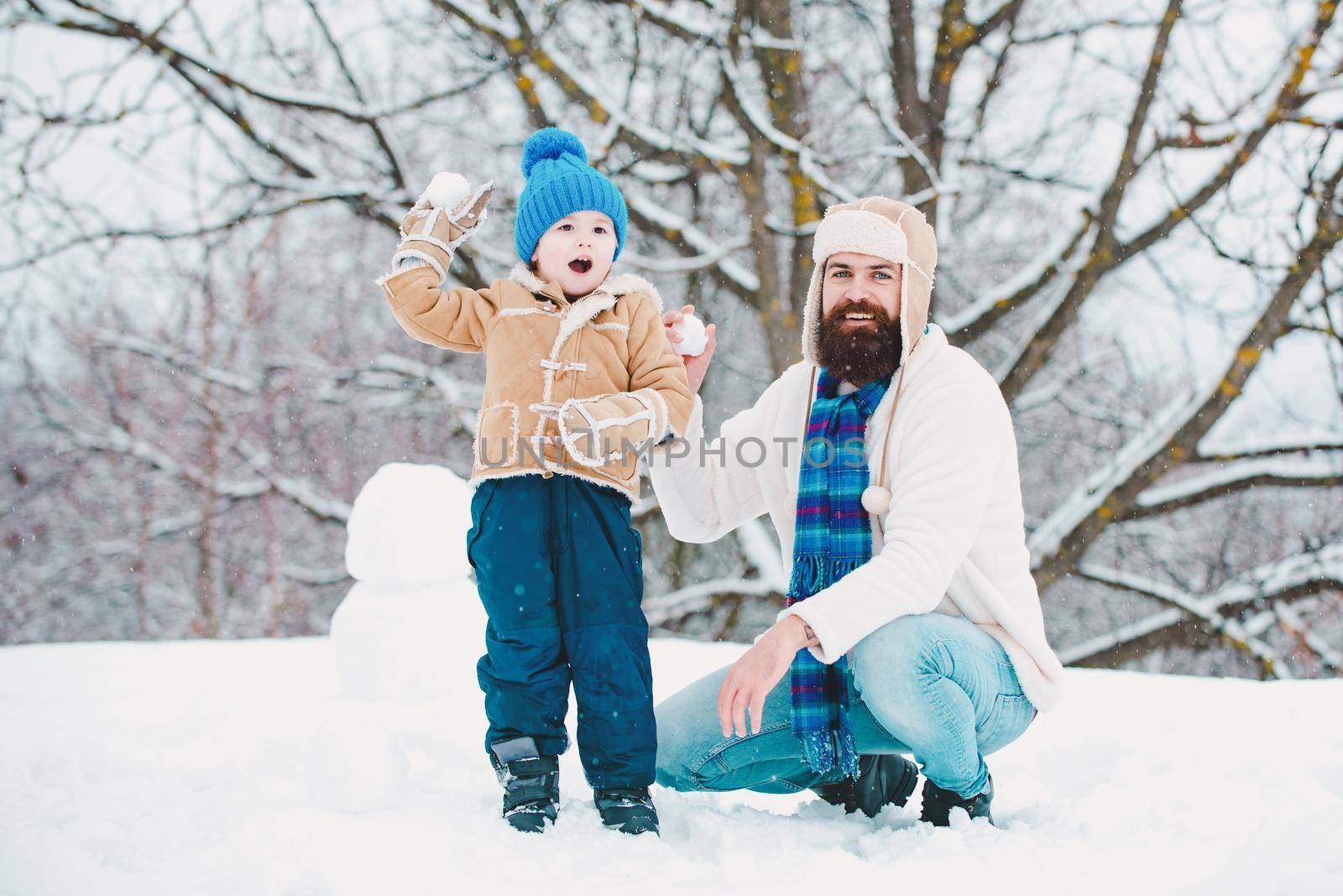 Winter, father and son play outdoor. Father and son play with snowball on winter white background. Christmas holidays with father