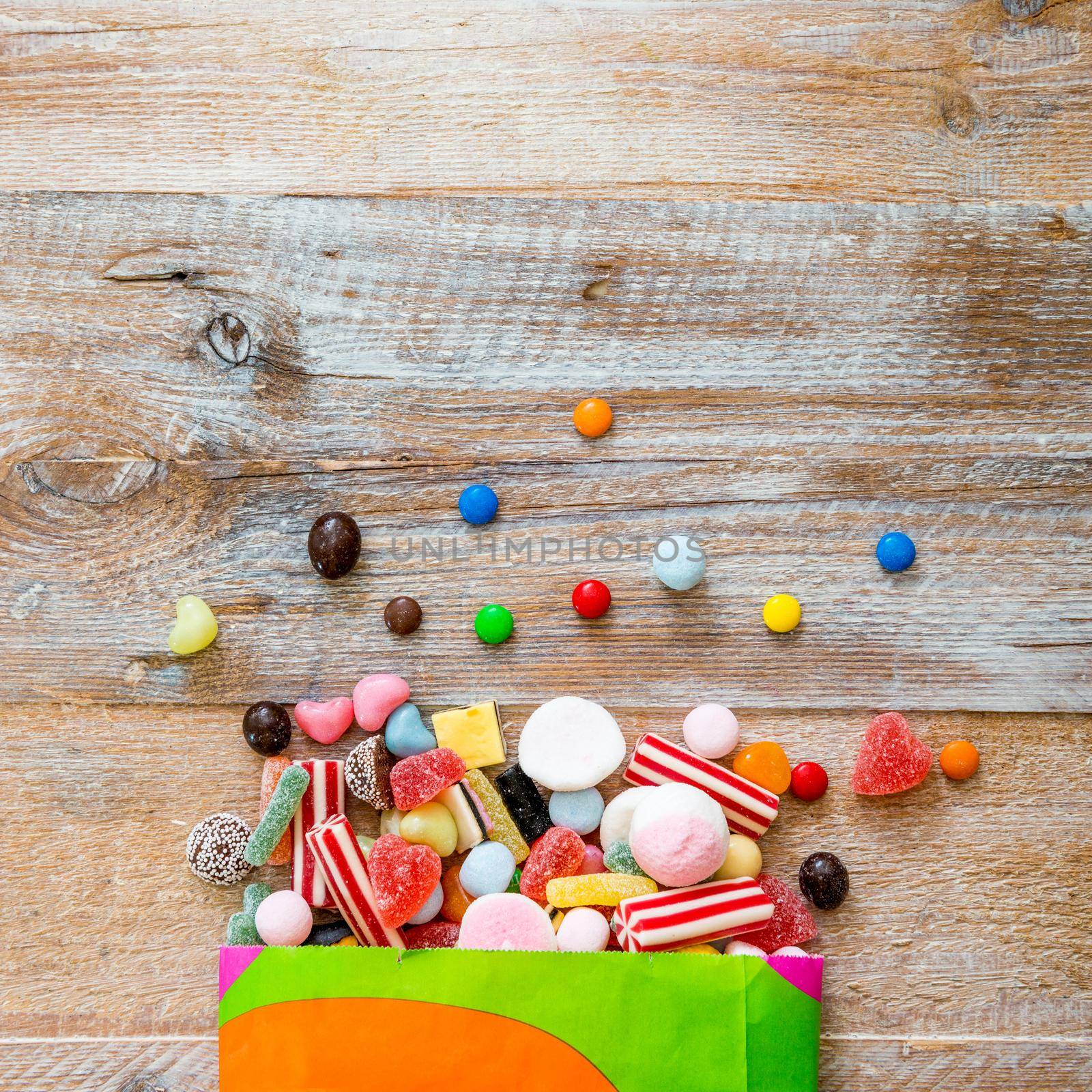 variety of candies on a wooden background with space for text