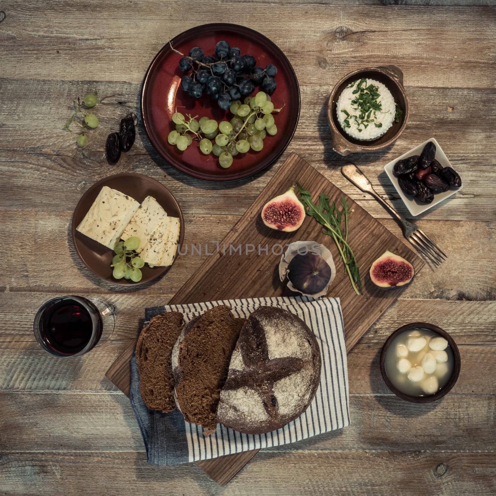 bread with cheeses and grapes on wooden background by tan4ikk1