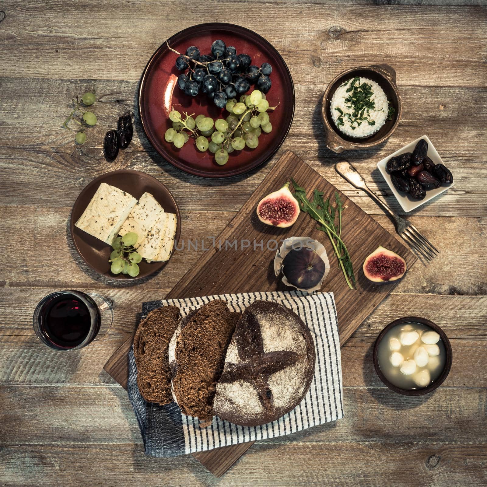 bread with cheeses and grapes on wooden background by tan4ikk1