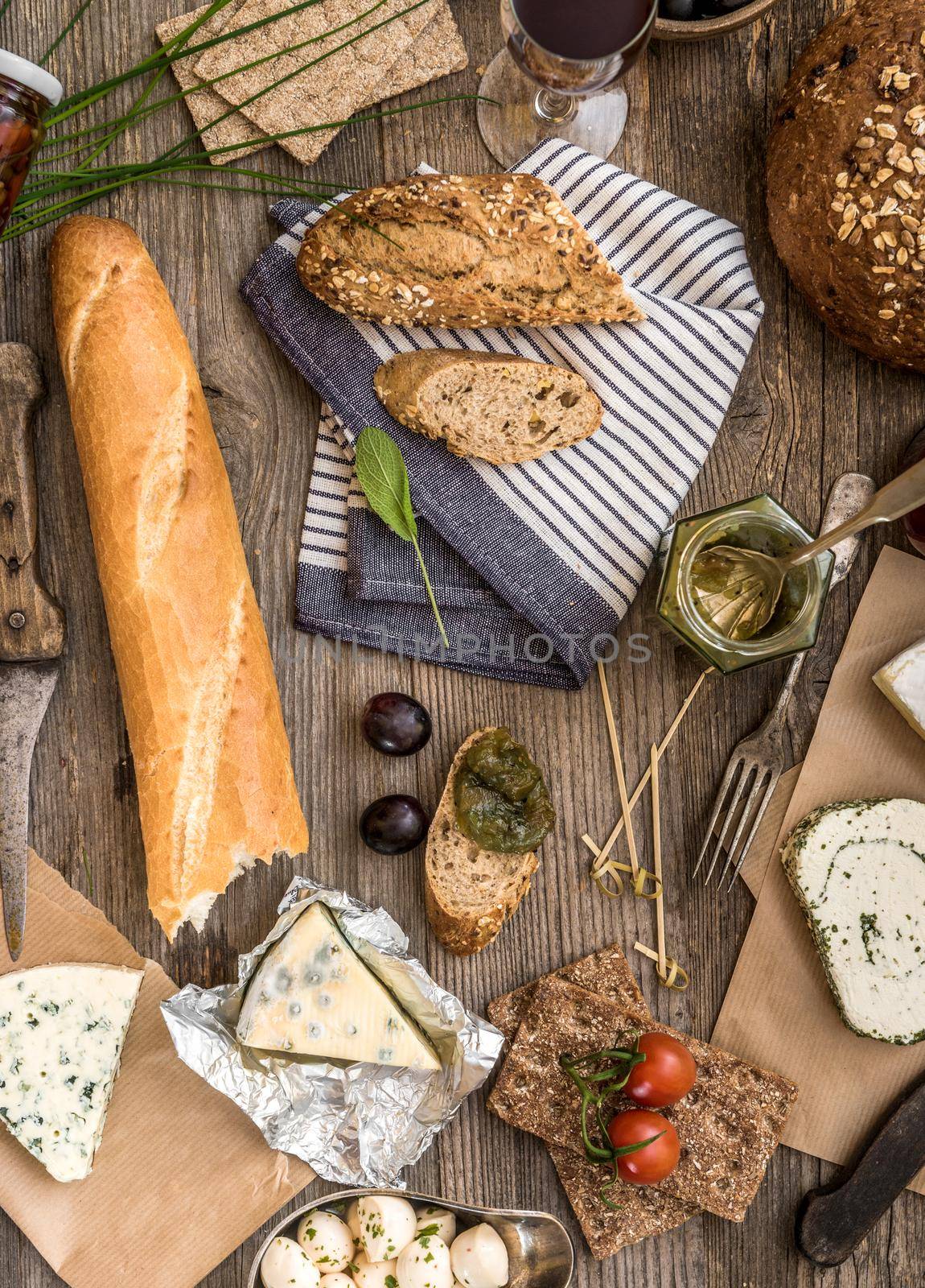 French food on a wooden background. Different types of cheese, wine and other ingredients on a wooden table