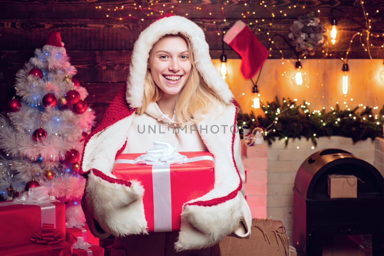 Beautiful Santa woman. Blonde Santa woman with Christmas gift. by Tverdokhlib