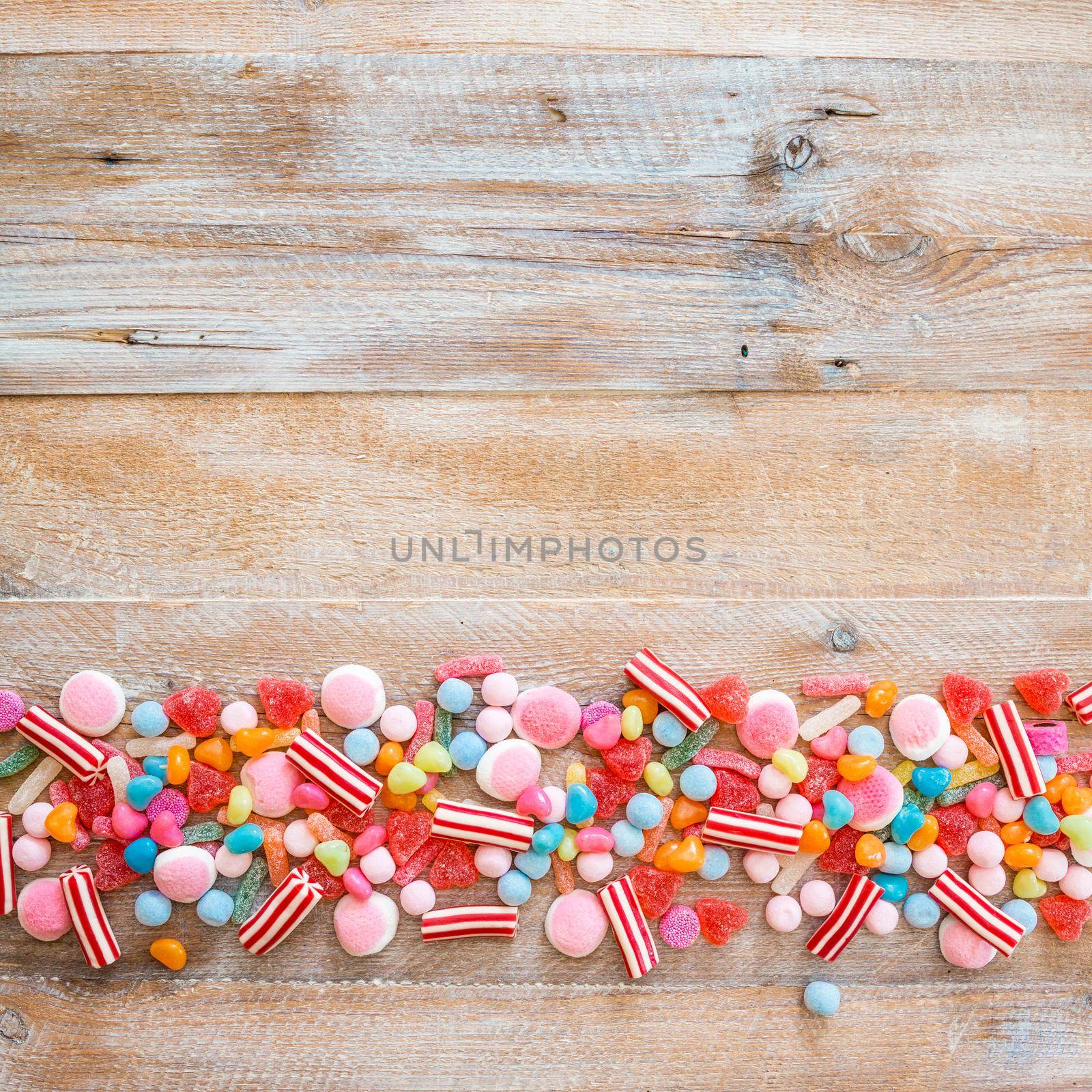 variety of candies on a wooden background with space for text