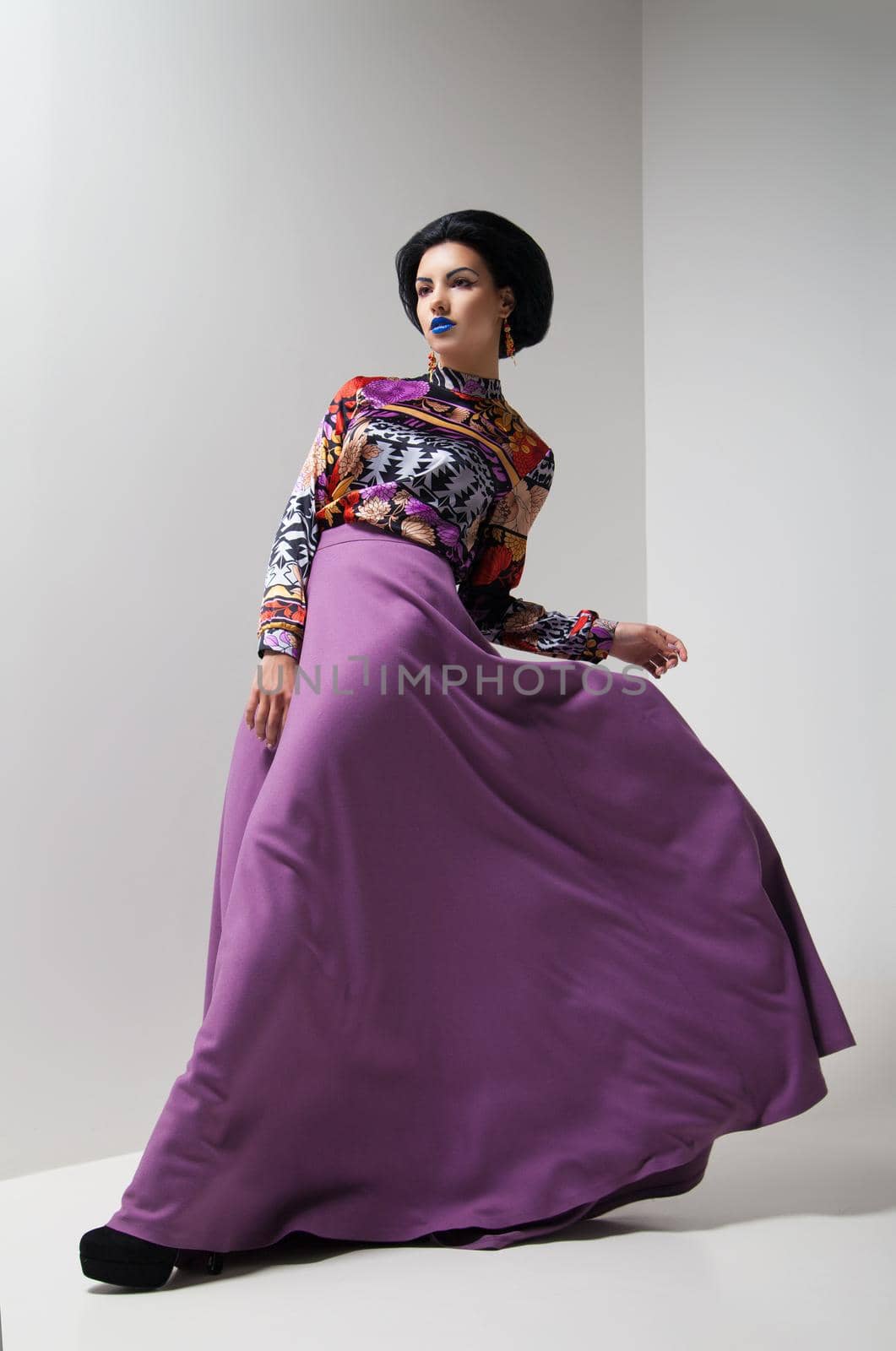 Fashion photo of young magnificent woman in purple dress. Studio photo