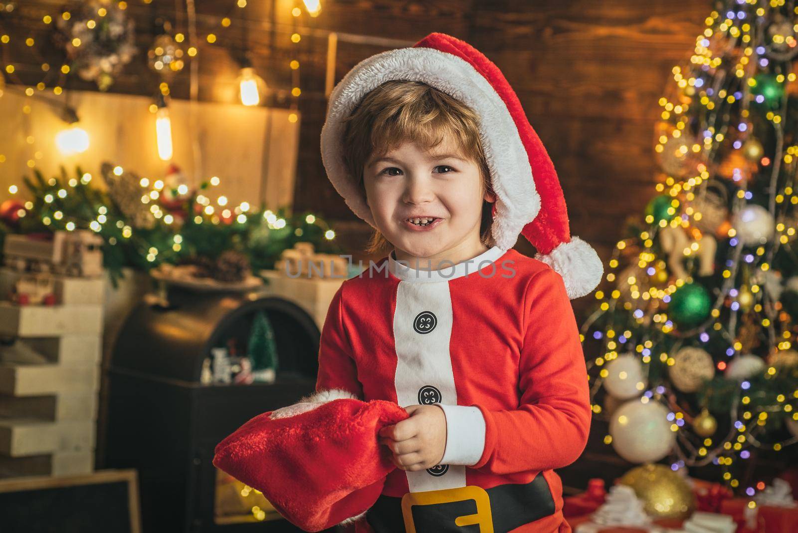 Funny christmas kids face. Happy little smiling boy with Christmas gift socks