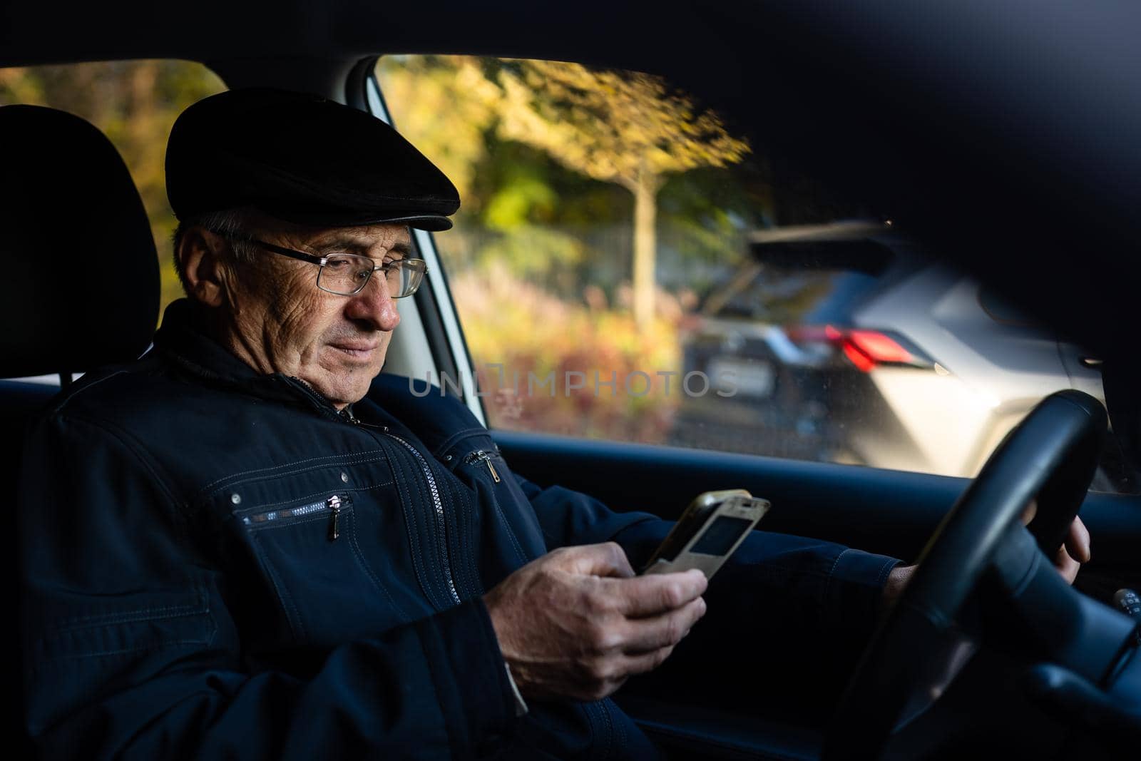 Elderly person driving a car. elderly man in a car