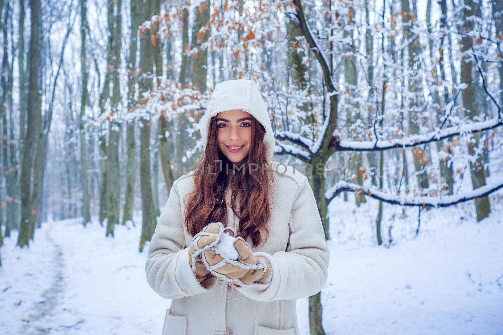 Winter woman fun. Girl playing with snow in park. Winter woman clothes. Winter woman snow. by Tverdokhlib