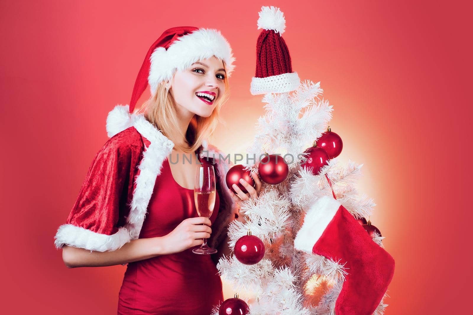 Pretty girl wish merry Christmas and happy new year. Festive champagne. Blonde girl celebration on red background