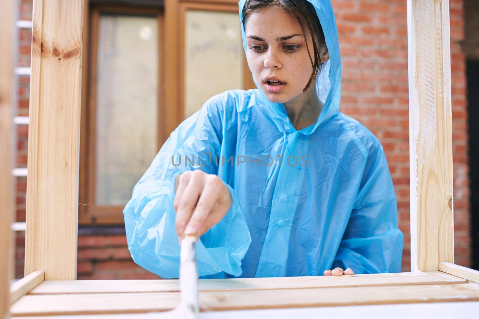 a painter with a brush in his hands paints wooden objects repairing fittings. High quality photo