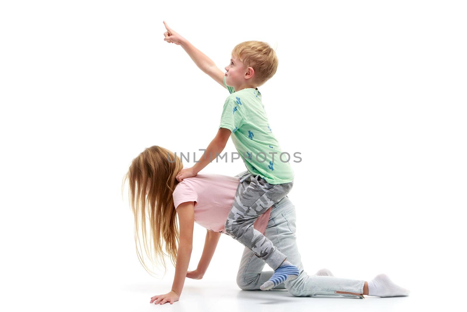 A little boy rides a girl like a horse. The concept of children's games. Isolated on white background.