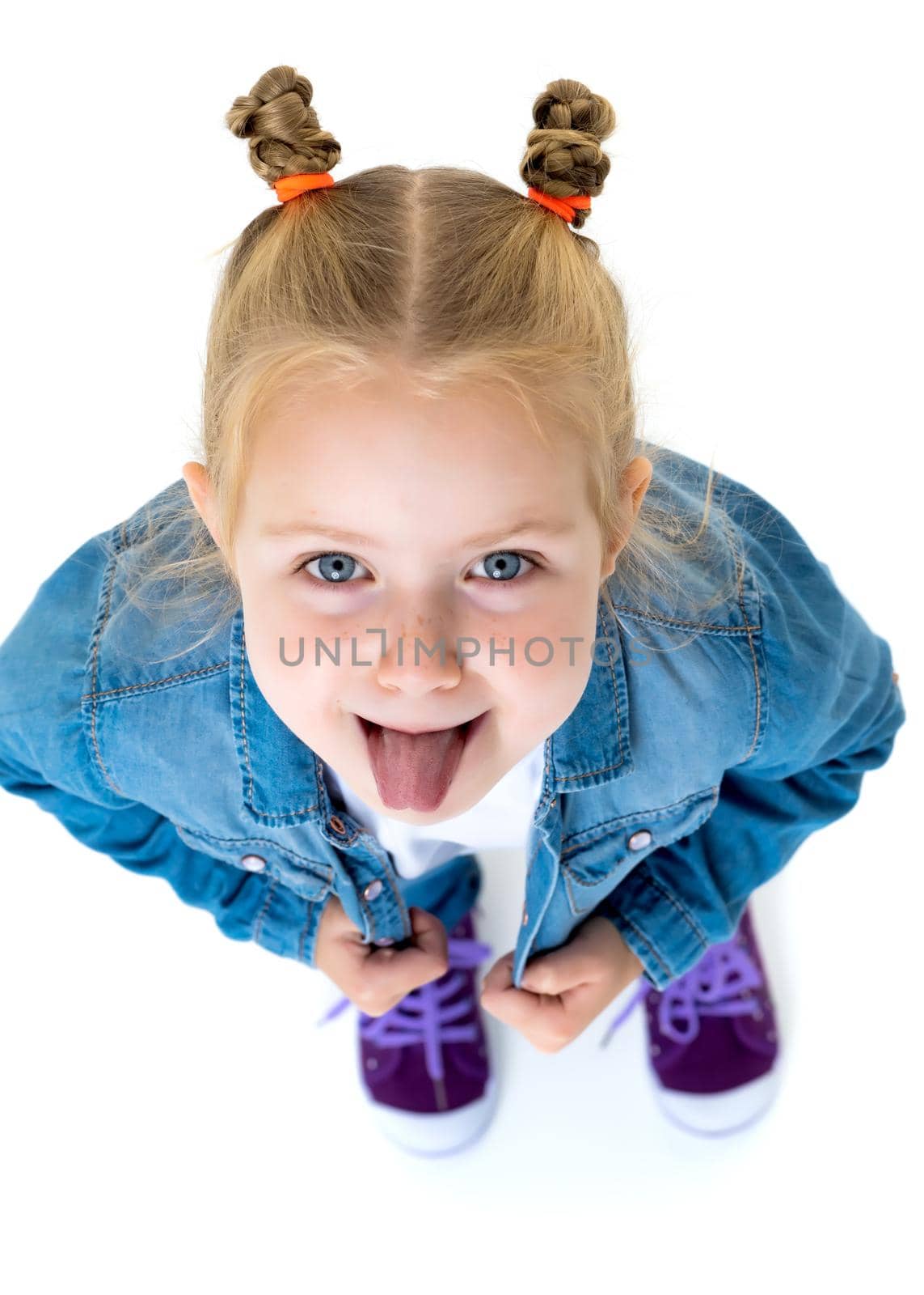 Cheerful little girl shows tongue. The concept of a happy childhood. Isolated on white background.