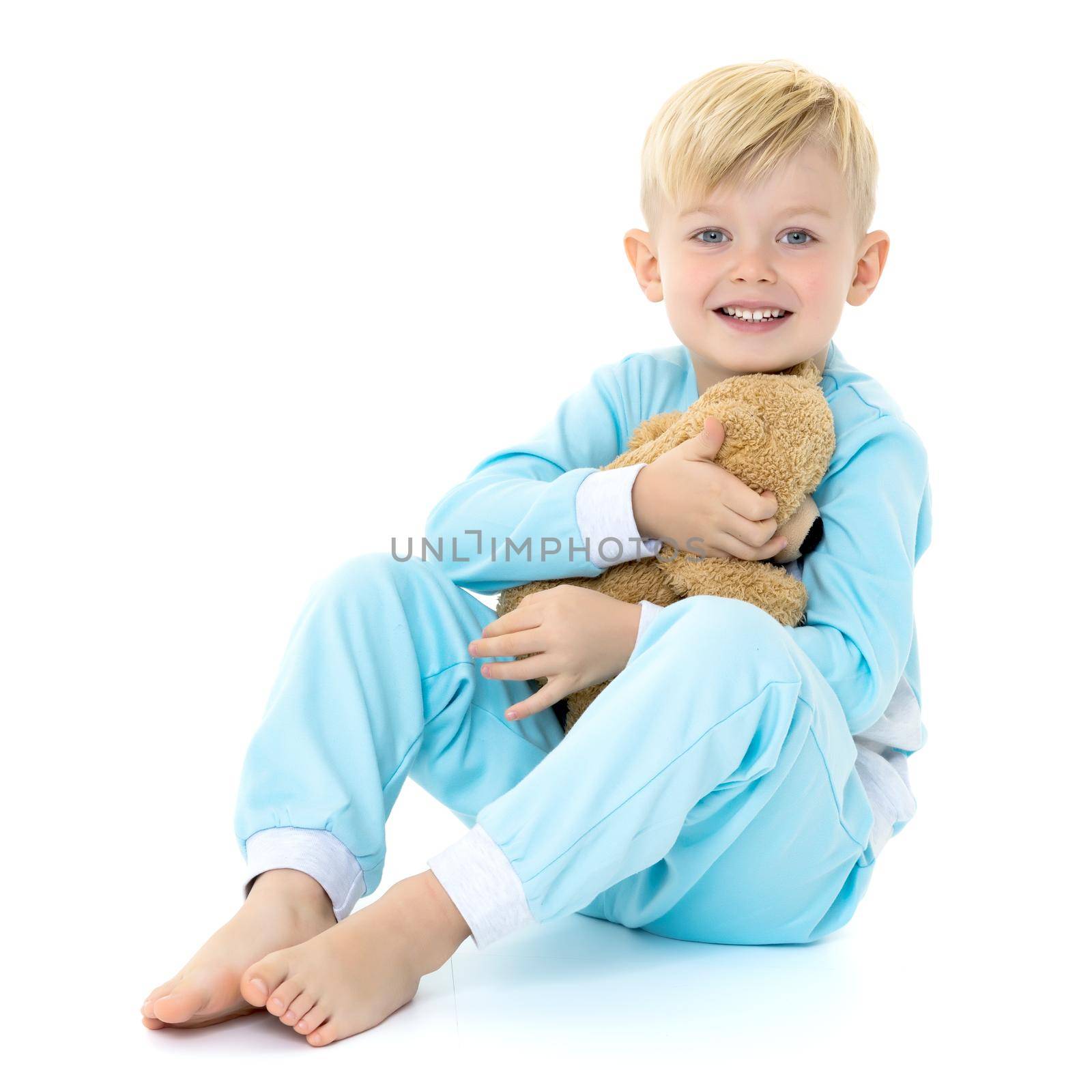 Cute little boy in pajamas with a teddy bear. The concept of family happiness. Isolated on white background.