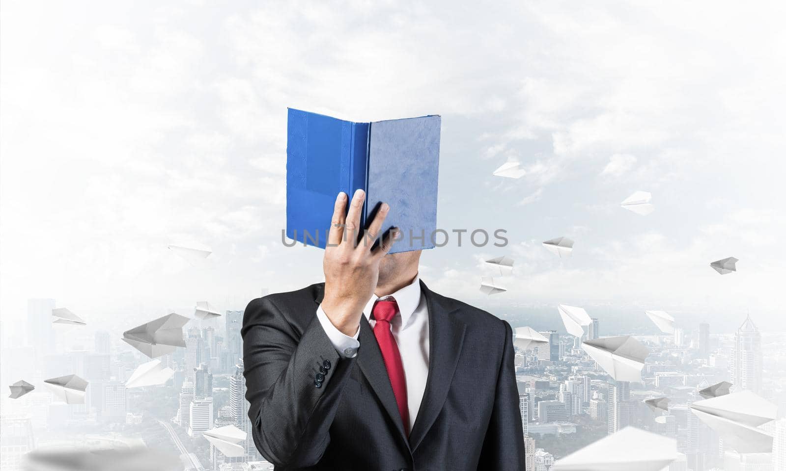 Businessman covered his face with paper organizer. Man in business suit standing on cityscape background with flying paper planes. Education and professional knowledges. Management and planning.