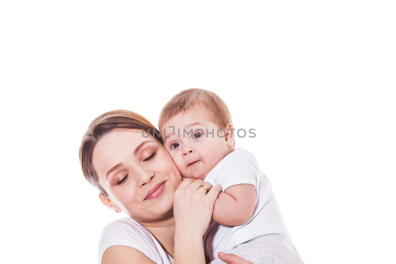 Portrait of happy mother and child embracing cheek to cheek on a white background. Mother with closed eyes holding baby's hand