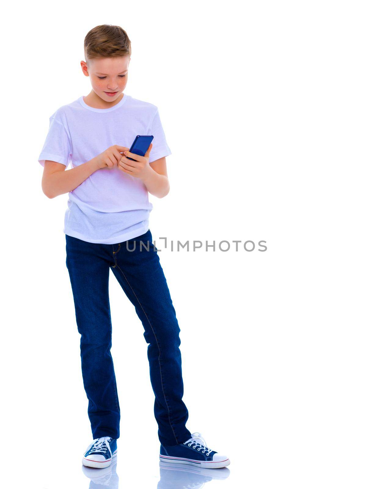 A little boy uses a mobile phone. by kolesnikov_studio