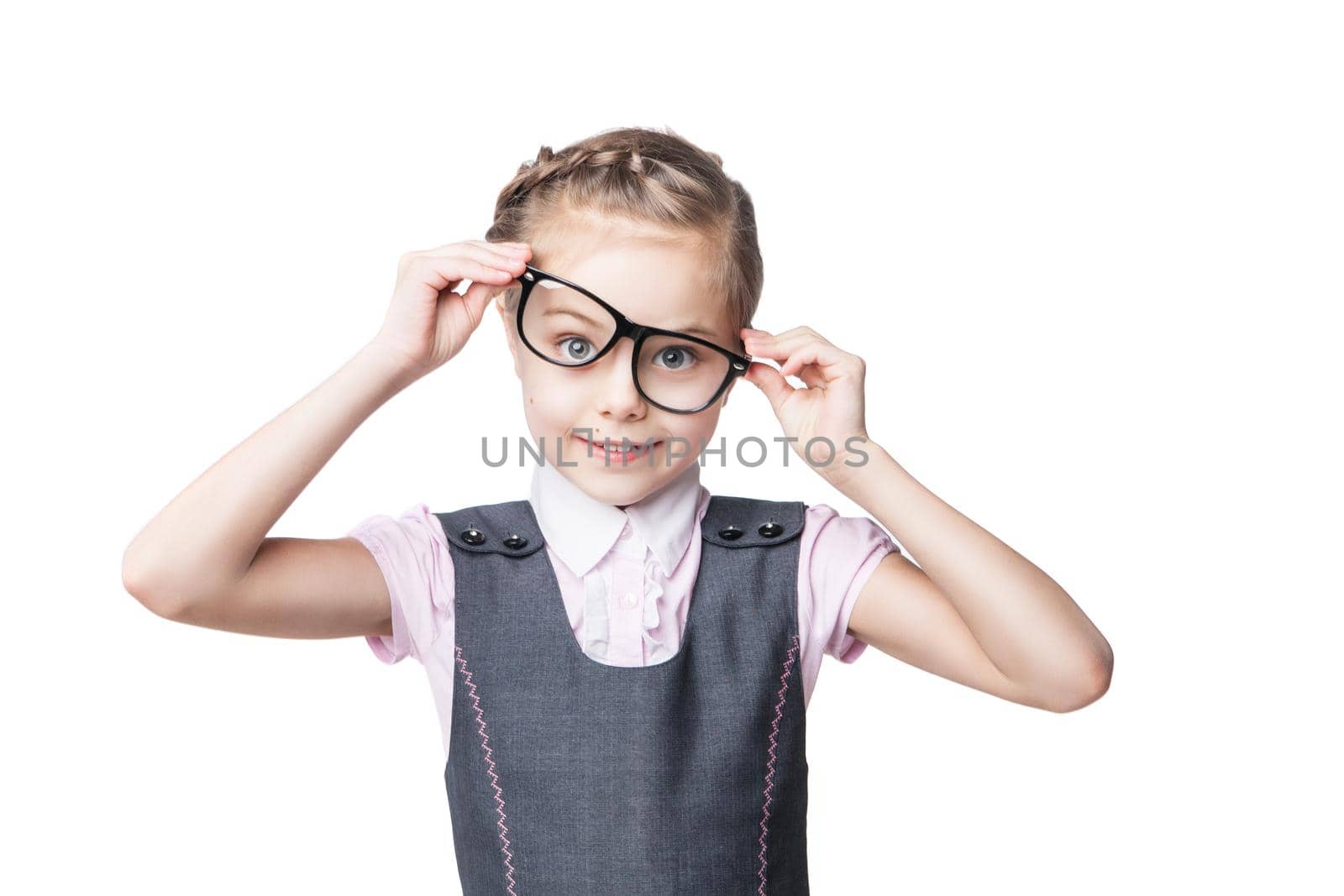 Portrait of a funny little girl on school uniform and glasses making faces